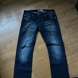 Mörkblå jeans från RPBL - Snygga mörkblå jeans från RPBL med klassisk femficksdesign och kontrastsömmar. Jeansen har en straight passform och är perfekta för en avslappnad stil. Märkesdetalj på baksidan av midjan.