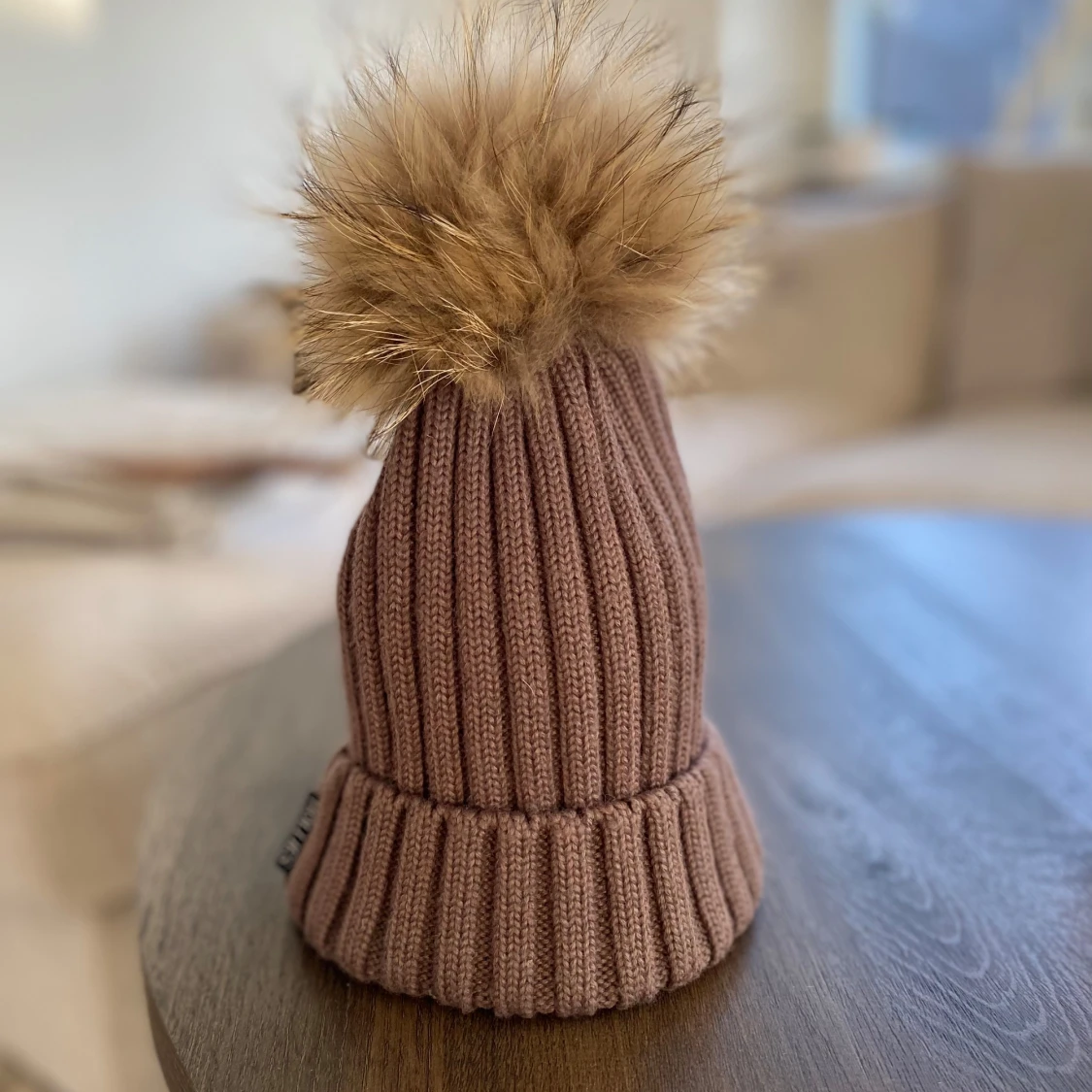 Brun stickad mössa med pälsboll