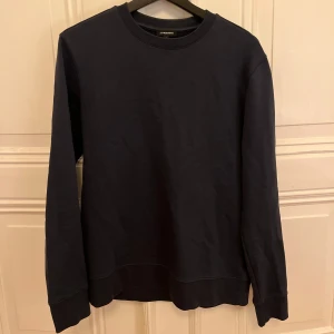 Mörkblå tröja från J.Lindeberg - Säljer en stilren mörkblå tröja från J.Lindeberg. Tröjan har en klassisk rund halsringning och långa ärmar. 