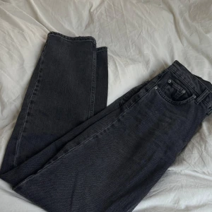 Svarta jeans från Perfect Jeans - Snygga svarta jeans från Perfect Jeans i storlek 32. De har en klassisk design med knapp och dragkedja framtill. Perfekta för en stilren look.