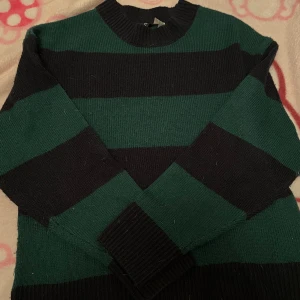 Randig stickad tröja från Divided - Säljer en snygg baggy stickad tröja från H&M i grönt och svart. Passar både xs och s. Lite dammig men tar bort det innan jag postar. Hör av dig vid intresse! 🫶