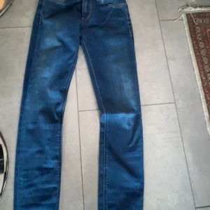 Blå skinny  jeans från Replay Anbass - Snygga blå jeans från Replay med en klassisk femficksdesign. De har en normal passform och är tillverkade i stretchigt denim för extra komfort. Perfekta för en avslappnad stil.