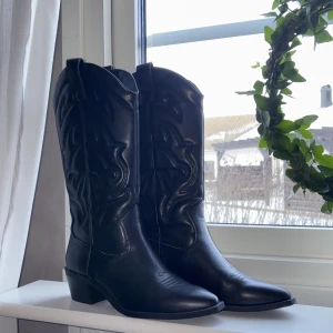 Svarta cowboy boots - Snygga svarta cowboy boots med dekorativa broderier. De har en spetsig tå och en låg klack. Endast använda en gång inomhus. Köpta för ca ett 4 mån sen. Säljer då jag inte använder dom. Hör av er vid frågor💘 Nypris: 699