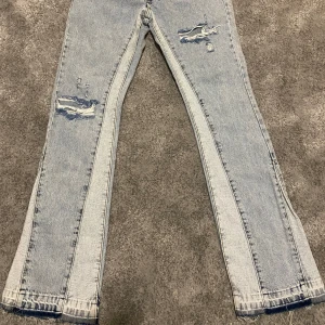 Flared jeans från boohooMAN - Snygga ljusblå jeans från boohooMAN med slitna detaljer och en slim fit passform. Storlek 32 vilket motsvarar S/M