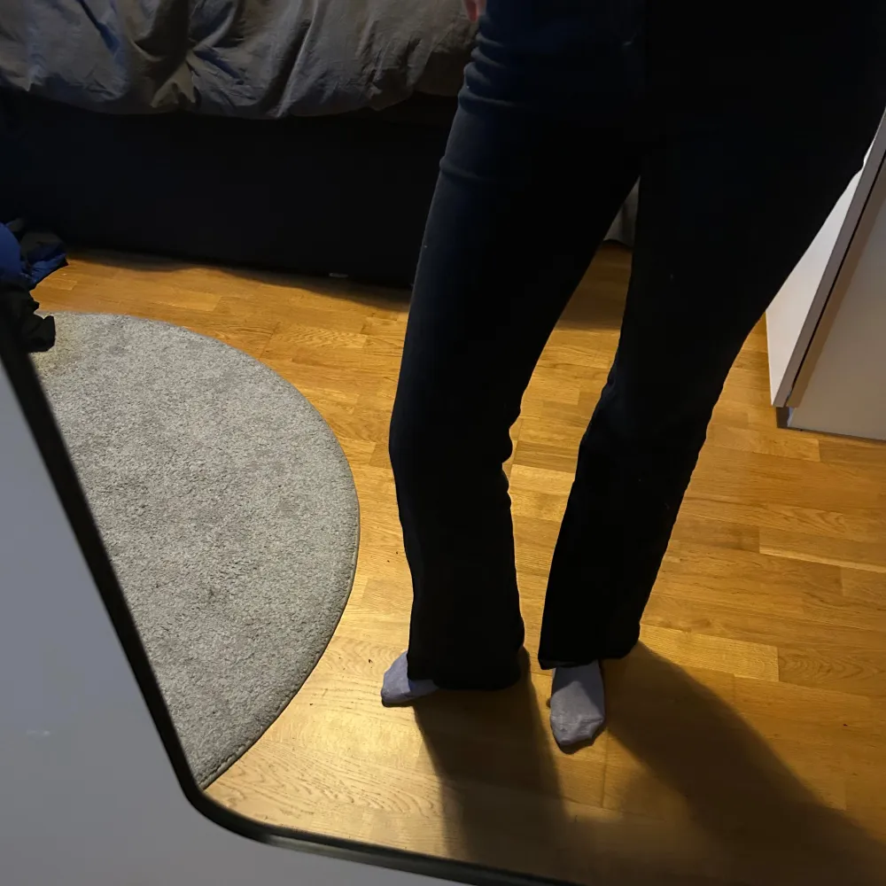 Snygga svarta bootcut jeans med hög midja. Perfekta för en stilren look. De har en klassisk design med knappar och dragkedja framtill.. Farkut & Housut.