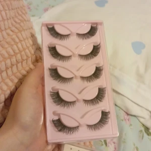 Set med lösögonfransar - Säljer ett set med fem par fylliga lösögonfransar i en rosa förpackning. Perfekta för att ge dina ögon en dramatisk look. Lätta att applicera och bekväma att bära hela dagen.