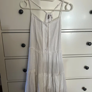 Vit klänning från Subdued - Säljer en söt vit klänning från Subdued i storlek XS. Klänningen har smala axelband och spetsdetaljer. Perfekt för student eller för sommarens varma dagar. 🌸
