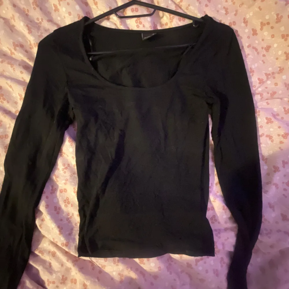 Säljer en stilren svart långärmad topp från Gina Tricot i storlek XS. Perfekt för en enkel och snygg look. Toppen har en rund halsringning och är gjord i ett mjukt material.. Neuletakit & Villapaidat.