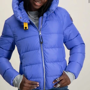 Blå dunjacka från Parajumpers - Snygg blå dunjacka från Parajumpers med huva och dragkedja. Jackan har en gul detalj vid halsen och en logotyp på ärmen. Nypris är 5399kr. Är som ny då den inte är använd så många gånger. Säljer pga att den inte används så ofta. Storlek 12 i barnstorlek vilket motsvarar 152-158cm. Passar även mig som är 158cm med en tjocktröja under. Kan även skicka egna bilder 🩷❤️