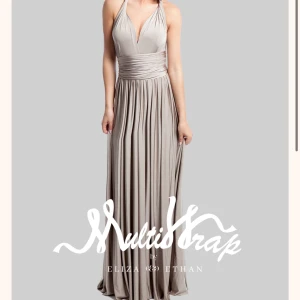 Balklänning - Så fin klänning från det fina märket Eliza & Ethan. Klänningen är en multiwrap klänning som går att knyta på hur många olika sätt som helst! Färgen är i Champange (första bilden). De andra bilderna visar lite olika sätt man kan knyta den på!😊 Köpt för 2500 och den är aldrig använd, lapparna kvar! Finns många bilder på nätet som visar olika sätt att knyta den på.