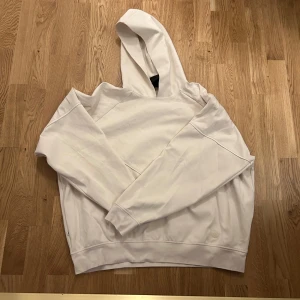 Vit hoodie - Säljer en stilren vit hoodie med en klassisk design. Den har en bekväm passform och en praktisk huva. Perfekt för en avslappnad look.