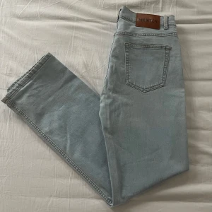 Monten jeans  - Snygga ljusblå jeansbyxor från Monten med en klassisk femficksdesign. Byxorna har en rak passform och är perfekta för en avslappnad stil. De är i bra skick och är i storlek W30 och L32