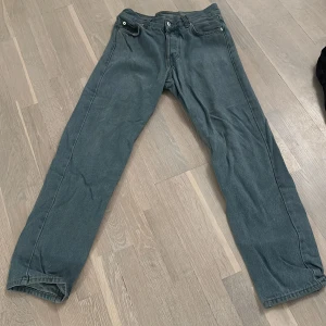 Grå jeansbyxor - Snygga grå jeansbyxor med klassisk design. De har en rak passform och är utrustade med knappar och dragkedja. Perfekta för en avslappnad stil.