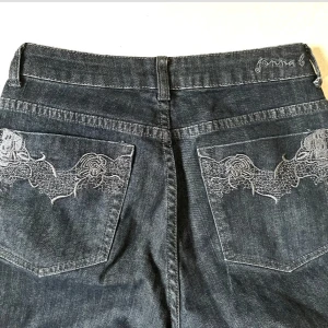 Svarta baggy jeans med broderi - Snygga svarta baggy jeans från Jonna B med unikt broderi på bakfickorna. Midwaist och har sprättat upp längst ned för att få de längre. Passar bra på mig som är 167 cm och har vanligtvis storlek S/36 💞