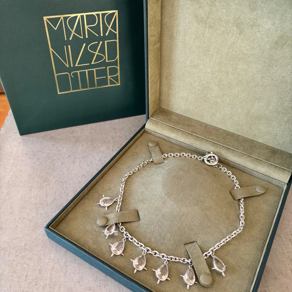 Unikt Queen of Chaos silverhalsband från Maria Nilsdotter med flera droppformade hängen. Halsbandet har en kedja med ett klassiskt lås. Äkthetsbevis finns. Låda ingår! Nypris ca 8000kr. Asusteet.