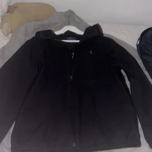 Svart jacka från Ralph Lauren - Hej! Säljer min Ralph lauren vindjacka/regnjacka. Storleken är i barn så det motsvarar s-m kommer passa er mellan 170-180cm. SKICK 9/10! PRIS KAN DISKUTERAS!