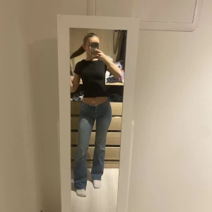 Blå bootcut jeans - Snygga blå bootcut jeans med låg midja. Perfekta för en avslappnad stil. De har en klassisk femficksdesign och stängs med dragkedja och knapp.