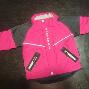 Rosa och svart jacka från Geggamoja - Säljer en cool rosa och svart jacka från Geggamoja i mycket fint skick. Praktiska dragkedjor på fickorna. Den är fodrad för extra värme och har reflexdetaljer för ökad synlighet. Perfekt för kyliga dagar! Obs saknar dock luvan.
