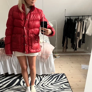 Röd dunjacka från Hilfiger Denim - Säljer en snygg röd dunjacka från Hilfiger Denim. Jackan har en pufferstil med långa ärmar och praktiska fickor framtill. Perfekt nu till vintern🥰 det står att den är storlek L men passar mig som är xs/s