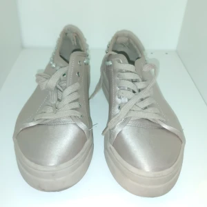 Beige sneakers från Zara - Snygga beige sneakers från Zara Basic Collection med pärldetaljer runt kanten. Skorna har snörning och en stilren design som passar perfekt för en trendig look.