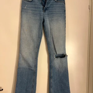 Blå bootcut jeans från Gina Tricot - Snygga ljusblå bootcut jeans från Gina Tricot med slitna detaljer på benen. De har en klassisk femficksdesign och en bekväm passform. Perfekta för en avslappnad stil. Mid waist. Skriv för fler bilder eller om ni har fler frågor 💓