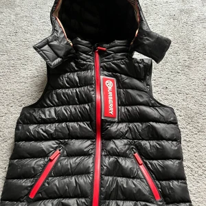 Burberry väst - Säljer nu min burberry väst som är köpt i nk i Stockholm för 2 år sedan. Köpt för 6000kr och är inte så använd. Man kan ta av luvan också.Finns i  Helsingborg. Ifall du har en fråga är det bara att skriva