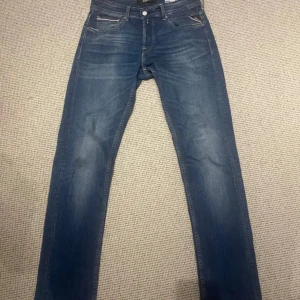 Replay jeans - Snygga blå jeans från Replay, modell Grover. De har en klassisk femficksdesign med dragkedja och knapp framtill. Jeansen är sparsamt använda och skicket är nästan som nytt.
