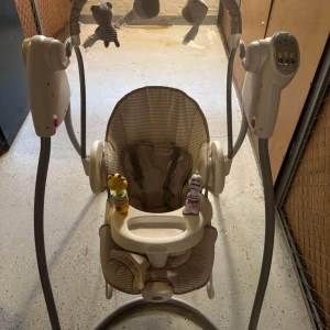 Elektrisk babysitter från Graco - Säljer en elektrisk babysitter från Graco i beige och bruna nyanser. Den har en stabil ram och en bekväm sits med säkerhetssele. Babysittern är utrustad med en kontrollpanel för att justera gungfunktioner och har hängande leksaker för underhållning. Perfekt för att lugna och roa ditt barn.