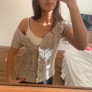 Beige stickad kofta med knappar - Snyggaste kortärmade stickade koftan🧡favorit i garderoben men har inte kommit till användning så säljer den! strlk S, möts upp eller postar