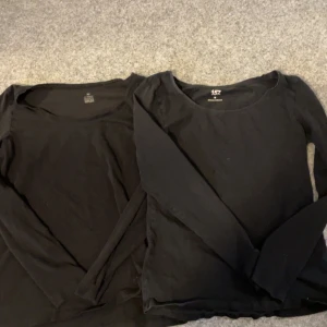 Svarta långärmade tröjor - Två svarta långärmade tröjor i enkel design.  De har en rund halsringning och är tillverkade i ett mjukt material för bekväm passform.
