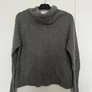 Grå stickad polotröja från Vila  - Mysig grå stickad polotröja från Vila. Perfekt för kyliga dagar med sin varma och bekväma design. Tröjan har långa ärmar och en klassisk polokrage som ger extra värme och stil. Passar även på M. Ett måste i garderoben! ❣️