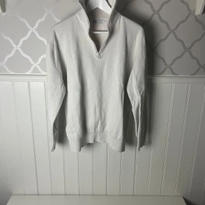 Vit tröja half-zip från Zara - Säljer en stilren vit tröja från Zara med dragkedja och hög krage. Tröjan har långa ärmar och är perfekt för en minimalistisk look. Passar bra till både jeans och chinos.