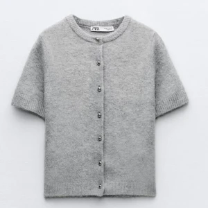 Grå kofta från Zara❣️❣️ - Säljer en stilren grå kofta från Zara med korta ärmar och knappar framtill. Super söt!!🥰🥰Storlek M me passar mig bra som brukar ha storlek S!! Koftan har en rund halsringning och är gjord i ett mjukt material. Priset kan diskuteras❤️❤️