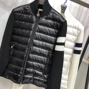 Svart quiltad jacka från Moncler - Säljer en snygg svart quiltad jacka från Moncler. Den har en cool kombination av glansigt material på framsidan och stickade ärmar med vita ränder. Jackan har dragkedja och två fickor med dragkedjor. Perfekt för höst och vår!