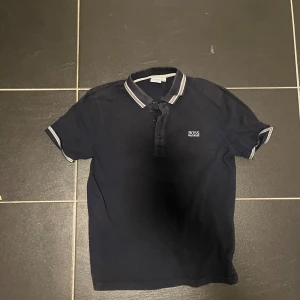 Hugo boss pike - Skön Hugo boss pike i bra skick och som är  i storlek 150. Den  är perfekt att ha på sig på sommaren eller utomlands  