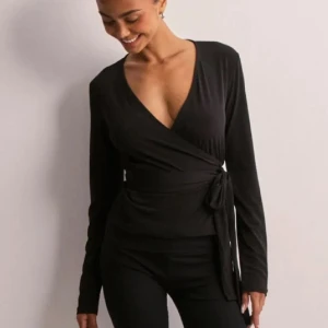 Svart omlottopp - Helt ny!!! snygg svart omlottopp från ginatricot med knytning i midjan. Perfekt för alla tillfällen. blev tyvärr för liten för mig 🫶🏽