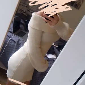 Vit stickad klänning - Säljer en superfin vit och lite  gulaktig stickad klänning som är perfekt för höst och vinter. Den har en offshoulder-design och långa ärmar, vilket gör den både mysig och stilren. Klänningen är tight och framhäver figuren på ett snyggt sätt. Perfekt för en fest eller en mysig dag hemma!