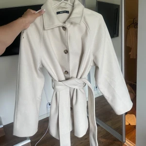 beige kort kappa - fin beige kappa från gina tricot i fint skick! säljer då den inte längre används 😊storlek M!
