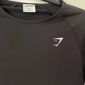 GYM SHARK TRÖJA - Tränings tröja från gym shark, helt ny men kom aldrig till användning. Tummhål. Lite kortare vid midjan. 