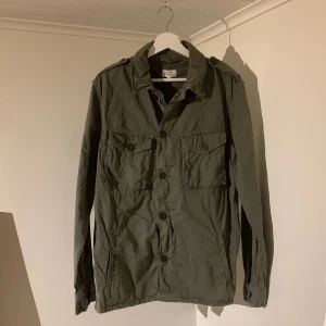Fieldjacka - Olivgrön - Säljer denna snygga Fieldjackan från Hartford just nu🍁🙌 Jackan är i mycket gott skick och har inga tydliga defekter✅ Färgen är olivgrön och storleken är M. Jackan passar perfekt till höst och vinter🙌🍁 Tveka inte på att höra av dig vid minsta fråga🤝⭐️