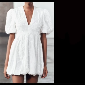 Zara klänning - INTRESSEKOLL på min gamla studentklänning! Snygg vit klänning med puffiga kortärmar och v-ringning. Den har ett broderat mönster och är perfekt för sommaren eller studenten. 