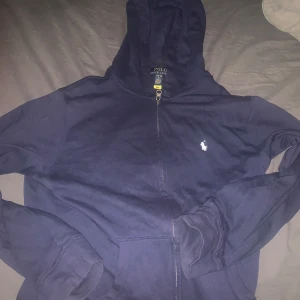 Mörkblå hoodie från Ralph Lauren - Säljer en snygg i mörkblå kofta från RL, storlek 14-16. Koftan är i nyskick alltså 10/10. Köptes för 1399kr, min pris 399kr!