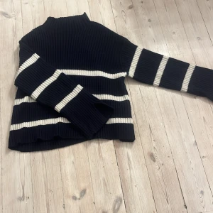 Svart och vit randig tröja från Kappahl - Säljer en snygg svart tröja från Kappahl med vita ränder. Den är ribbad och har långa ärmar, perfekt för höst och vinter. Tröjan är i mycket bra skick och passar både till vardags och lite finare tillfällen. Supermysig och stilren!