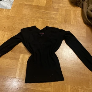 Svart tröja från MarPhilippe - Säljer en stilren svart tröja från MarPhilippe i storlek S. Tröjan har en v-ringad design och är perfekt för både vardag och fest. Den är i mycket bra skick och passar utmärkt till höst- och vintergarderoben.