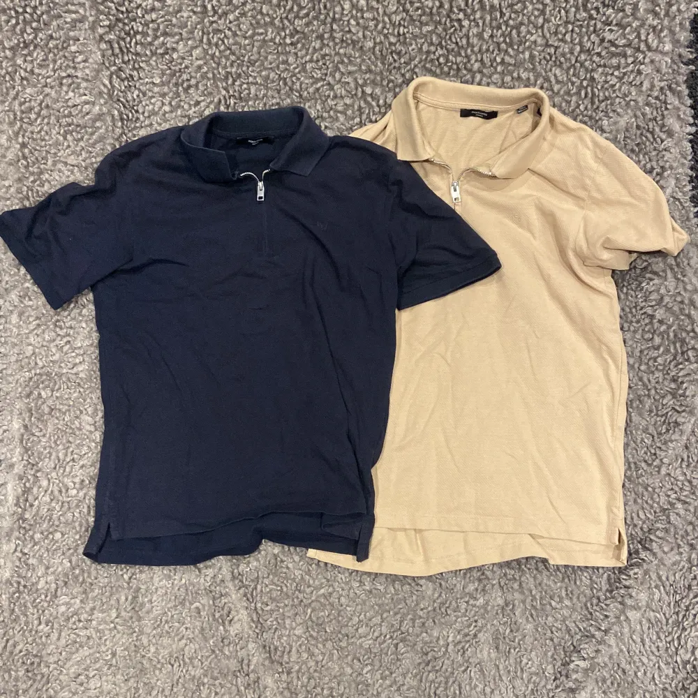 Säljer två snygga pikétröjor från Jack & Jones. En i marinblå och en i beige, båda med korta ärmar och dragkedja vid halsen. Perfekta för en avslappnad stil, oavsett om det är vår eller sommar. De är i bra skick och redo för nya äventyr! Storlek: S. T-shirts.