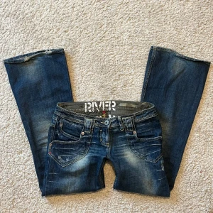 Lågmidjade bootcut jeans - Säljer dessa snygga mörkblå vintage jeans!🙌🏼 midjemått rakt över: 41 cm, innebenslängd: 77 cm, benbredd: 26 cm