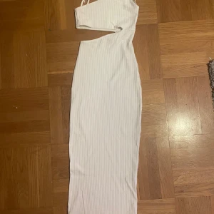 Vit lång tajt klänning  - Vit, klänning, tajt, xxs, modern, stylish, ribbad, använt 1 gång, jag är 171cm och den går till mitten av mina smalben typ, tunn, bra om man ska vara finnklädd, unik.