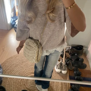 Beige stickad axelväska med kedja - Säljer en superfin beige stickad axelväska med en snygg guldkedja. Perfekt för både vardag och fest! Väskan är i mycket bra skick och har en mysig, handgjord känsla. Passar perfekt till höst- och vinteroutfits. 👜✨