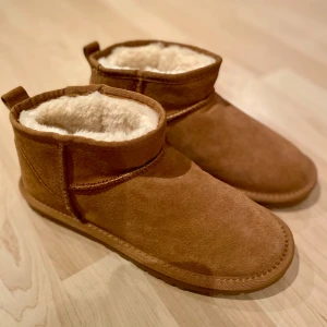 Ugg-liknande boots - Uggs-liknande (mini) som är lite små i storleken. Jag har 2 par likadana (upplagt i varsin annons) som båda är storlek 38 (fast det står stl 39 på dem). Beige.   Superfina och sköna! Helt oanvända eftersom de var för små för mig/oss. 