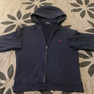 Ralph laruen zip hoodie - Säljer denna tröja på grund av att den är för liten för mig, har använt den fåtals gånger så den är i mycket bra skick. Köpte tröjan förra året ifrån Ralph laurens hemsida och qr kod finns i tröjan att skanna
